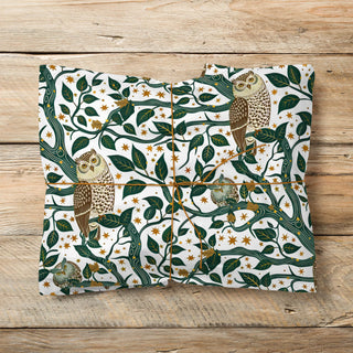 Packaged product with owl and leaf design on a wooden surface